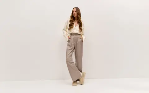 Elegancka kobieta w luźnych spodniach i koszuli. Lyocell: wady i zalety tego materiału w modzie.