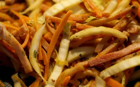 Pokrojone w słupki marchewka, fasolka i inne warzywa w daniu stir-fry.