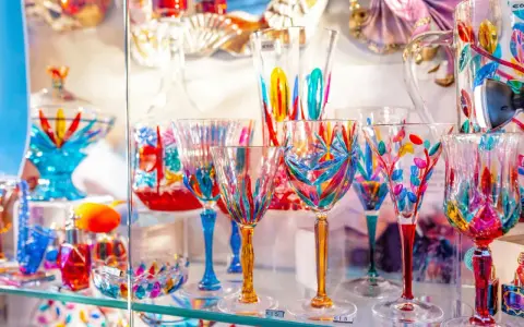 Verrerie colorée et artisanale, un aperçu du musée du verre Murano. Des coupes et verres aux motifs floraux et géométriques éclatants.