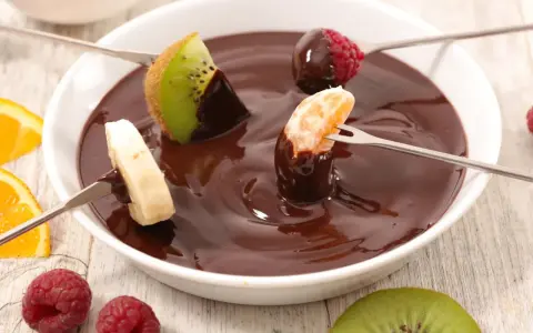 Deliciosa fondue de chocolate receta con frutas: kiwi, plátano, mandarina y frambuesas. ¡Un postre perfecto para compartir!