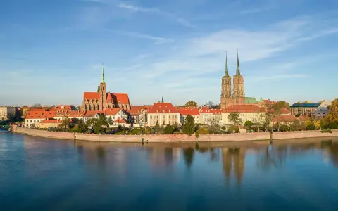 Wrocław stare miasto z katedrami i Ostrów Tumski nad Odrą, odbijające się w spokojnej wodzie.