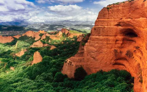 Paisaje dramático de Las Médulas, uno de los parques de España más impresionantes, con sus rocas rojizas y vegetación exuberante.