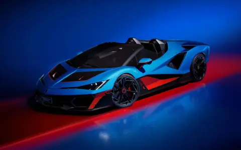 Ein blauer Lamborghini Veneno Roadster mit roten Akzenten steht auf einem glänzenden Boden, beleuchtet von rotem und blauem Licht.