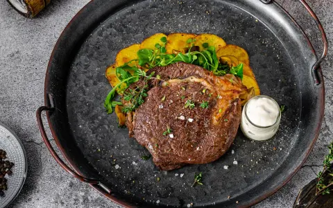 Un jugoso lomo bajo de vaca a la parrilla, acompañado de patatas crujientes y una salsa cremosa. ¡Un festín para los sentidos!