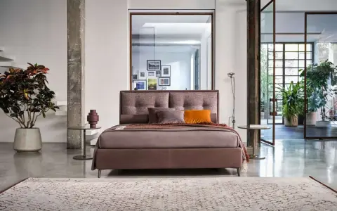 Elegante letto con testiera imbottita, parte di una collezione di **marchi camere da letto** di design.