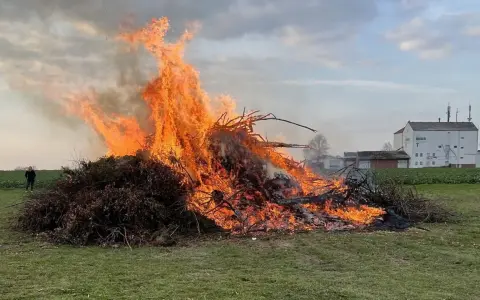 Großer Osterfeuer-Brauch: Ein Mann beobachtet die Flammen. Typische Oster Veranstaltungen.