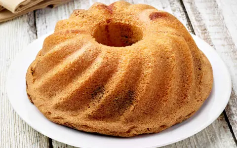 Ciambellone senza uova dorato e soffice, con la sua forma a ciambella, pronto per essere gustato.
