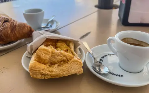 Ein Espresso und ein Croissant – so trinkt man in Italien! Dazu ein süßes Gebäck.