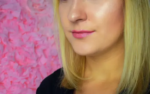 Rozświetlona cera dzięki podkładowi Mary Kay. Delikatny róż na ustach i zielone oczy.