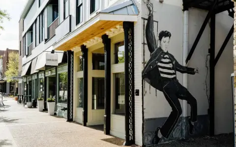 Elvis Presley Geburtsort: Ein Wandgemälde des King of Rock 'n' Roll ziert die Fassade eines Gebäudes in einer charmanten Straße.