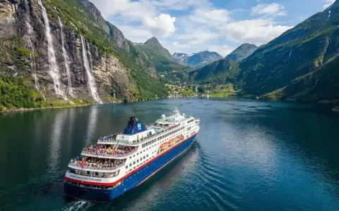 Rejs statkiem "Norwegian Fjord Explorer" przez malownicze fiordy Norwegii, z wodospadami i zielonymi zboczami.
