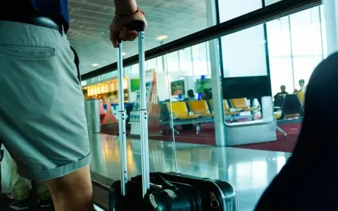 Osoba z walizką czeka na lot tunezyjskich linii lotniczych Nouvelair.