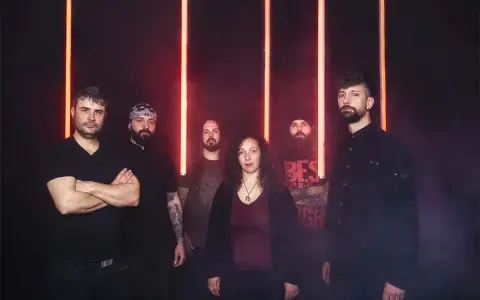 Cinco personas posan ante luces rojas. La banda Otero Brutal Fest lista para un concierto.
