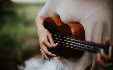 Dłoń grająca na ukulele, które jest często uważane za instrument, na którym najłatwiej nauczyć się grać.