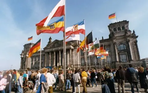 Många flaggor vajar framför Riksdagshuset i Berlin, en symbol för nationell stolthet och nationalismens betydelse.