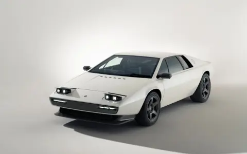 Biały Lotus Esprit z lat 80. z charakterystycznymi podnoszonymi światłami i sportowymi felgami.