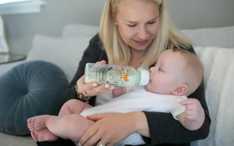 Mama karmi dziecko z butelki antykolkowej Dr Brown's z uroczym motywem lisów.
