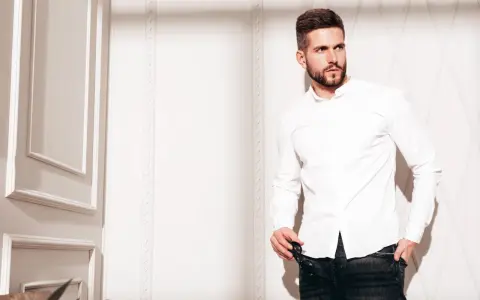 Mężczyzna w białej koszuli i jeansach, prezentujący styl slim fit.