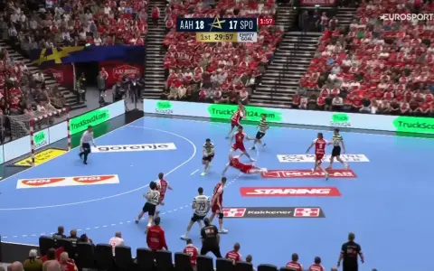 Piłkarze FC Barcelona Handball w akcji, walczą o każdą bramkę. Dynamiczna gra na parkiecie, tłumy kibiców na trybunach.
