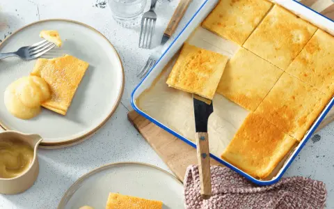 Goldbraune Pfannkuchen vom Blech, frisch aus dem Ofen, werden mit Apfelmus serviert. Ein Genuss für die ganze Familie!