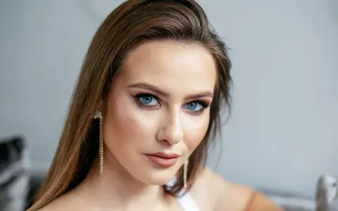 Kobieta z brązowymi włosami i niebieskimi oczami, idealnie dobrany makijaż podkreślający urodę. Jaki kolor włosów do niebieskich oczu? Brązowy wygląda zjawiskowo!
