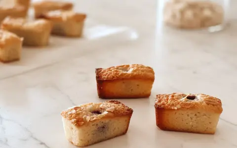 Financiers dorés, parfaits pour une recette financier framboise. Ils sont garnis de fruits rouges et de flocons d'amandes.