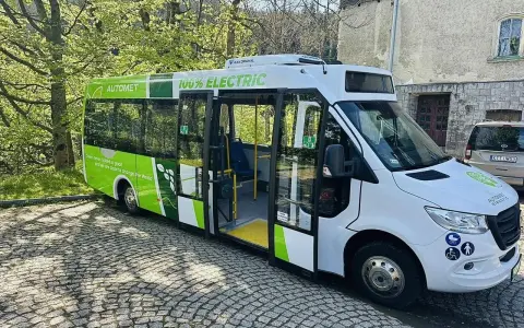 Zielony, elektryczny Automet gotowy do zabrania turystów na Morskie Oko. Ekologiczny transport w malowniczym otoczeniu.