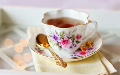 Elegancka filiżanka z kwiatowym wzorem, pełna aromatycznej herbaty. Czy herbata nawadnia? Ta z pewnością tak, dodając chwili relaksu.