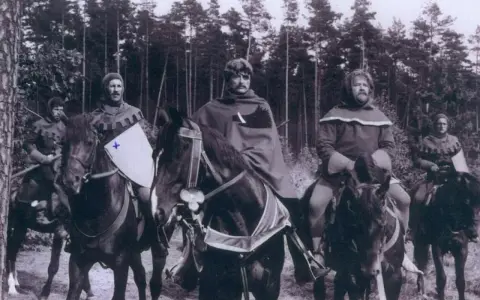Scena z filmu, gdzie kręcono bitwę pod Grunwaldem. Rycerze na koniach w lesie, przygotowani do walki.