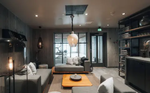 Mysig lounge med soffor och ett gym i bakgrunden på Niehku Mountain Villa.