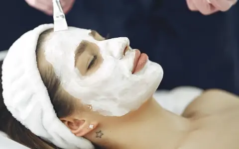 A woman receives a soothing facial mask application. This is a relaxing facial vs massage experience.