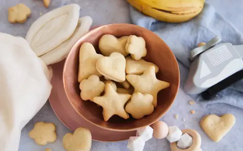 Kleine Sterne und Herzen: Baby Kekse backen ab 6 Monate. Dazu Bananen und ein Holzspielzeug.