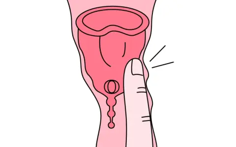Dłoń naciska na kubeczek menstruacyjny. Tworzywo TPE, choć popularne, może budzić pytania o jego szkodliwość.