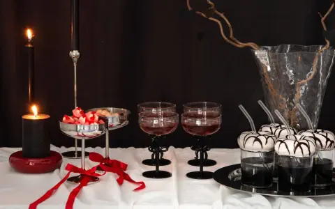 Ett festligt dukat bord med ljus, godis och drinkar. De svarta ljusstakarna med rosetter barn-tema ger en elegant touch.