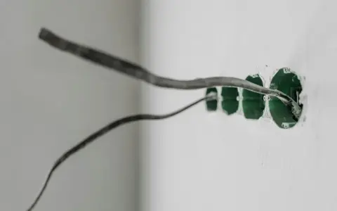 Instalacja elektryczna w ścianie z puszkami pod gniazdka. Uziemienie w gniazdku to klucz do bezpieczeństwa.