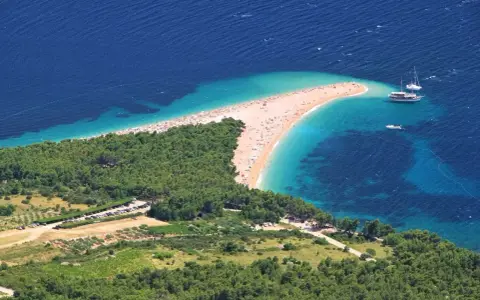 Zloty piasek i turkusowa woda na chorwackiej plaży. Idealne miejsce na bezpośrednie loty do Chorwacji.