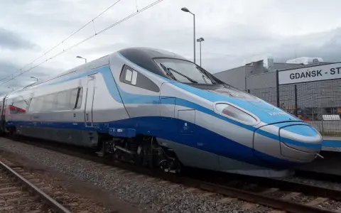 Nowoczesny pociąg Pendolino w kolorach biało-niebieskim stoi na torach przy peronie.