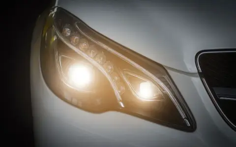 El **alumbrado de cruce** de un coche moderno ilumina la noche con sus potentes luces LED, listo para cualquier viaje.