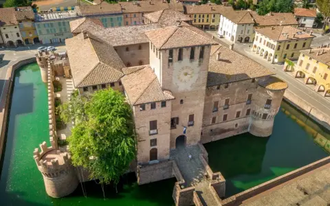 Castello di San Martino in Rio, uno dei tanti splendidi posti da visitare in Emilia Romagna, circondato da un fossato verde.