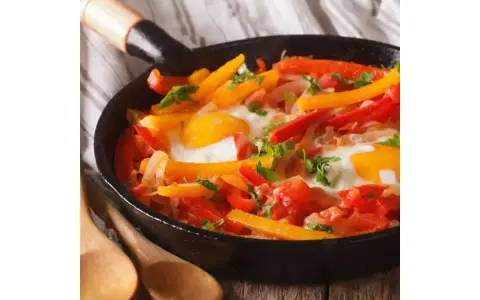 Poêlée colorée de poivrons et œufs, un plat savoureux qui rappelle la recette piperade grand-mère.