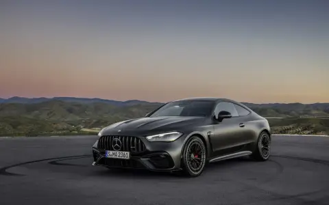 Ciemnoszare coupé Mercedes-AMG CLE 53 na tle górskiego krajobrazu o zachodzie słońca.