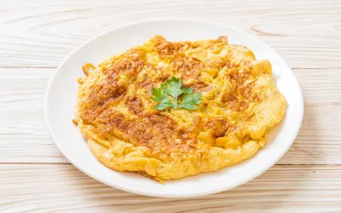 Frittata dorata e soffice, preparata in friggitrice ad aria, guarnita con un ciuffo di prezzemolo fresco.
