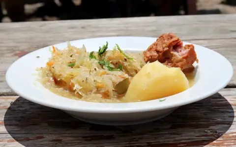 Danie z restauracji Bacówka: ziemniaki, kapusta kiszona z marchewką i kawałek mięsa. Pyszne, tradycyjne danie z menu.