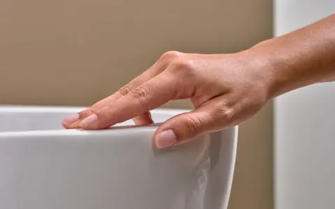 Eine Hand streicht über eine weiße Oberfläche. Mögliche Keratect Nachteile könnten hier eine Rolle spielen, wenn die Oberfläche empfindlich ist.