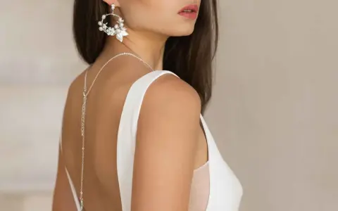Delikatne kolczyki i naszyjnik z tyłu podkreślają elegancję sukni ślubnej. Idealna biżuteria do sukni ślubnej.