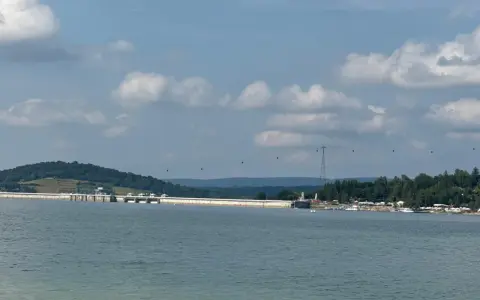 Widok na zaporę w Solinie, z widocznymi gondolami kolejki linowej i licznymi szlakami turystycznymi w tle.