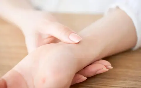 En elitidrottare känner sin vilopuls. En hand vilar på handleden, fingrarna känner efter pulsslag.