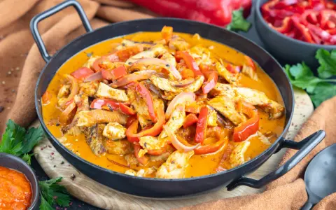 Ein einfaches Putengeschnetzeltes-Rezept mit Paprika und Zwiebeln in cremiger Sauce, serviert in einer Pfanne.