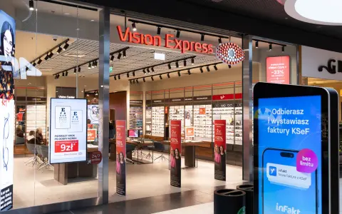 Witryna sklepu Vision Express z ekspozycją okularów i ekranem informacyjnym.