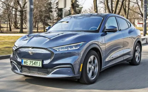 Niebieski Ford Mustang Mach-E w ruchu drogowym, widok z przodu.